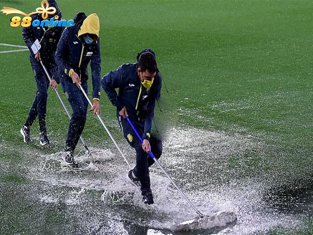 Ban huấn luyện Villareal dọn nước khỏi sân sau cơn mưa lớn trước trận đấu vòng bảng UEFA Europa League